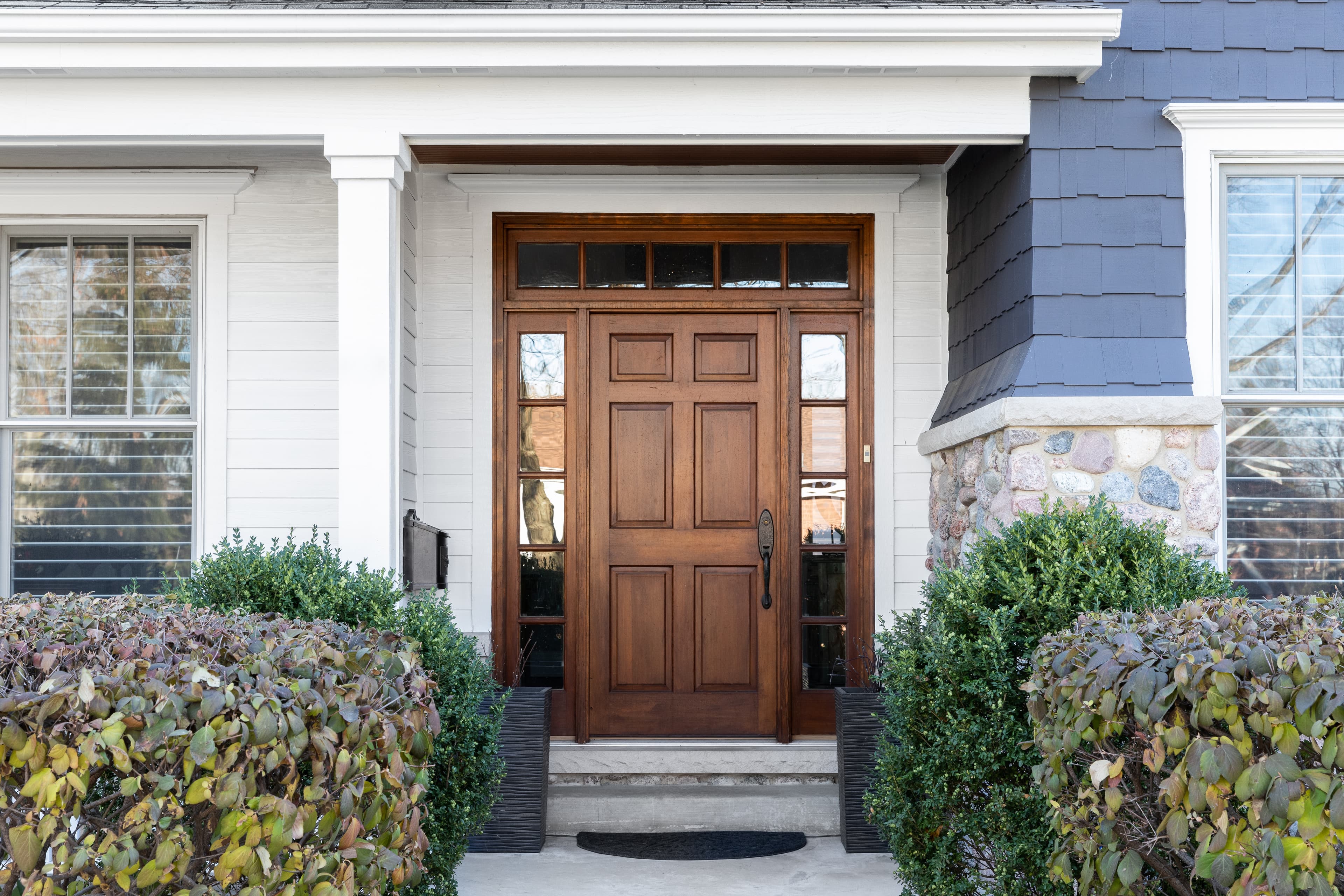 Six-panel wood entry door with glass sidelights and transom